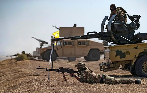 A fighter of the Syrian Democratic Forces (SDF) aims a machine gun while lying prone during a joint military exercise with forces of the US-led "Combined Joint Task Force-Operation Inherent Resolve" coalition against the Islamic State (IS) group in the countryside of the town of al-Malikiya (Derik in Kurdish) in Syria's northeastern Hasakah province on September 7, 2022. (Photo by Delil SOULEIMAN / AFP) (Photo by DELIL SOULEIMAN/AFP via Getty Images)